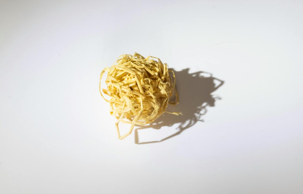pexels-photo-32632064-32632064 A ball of tangled raffia on a white background casting an intricate shadow. Perfect for design projects.