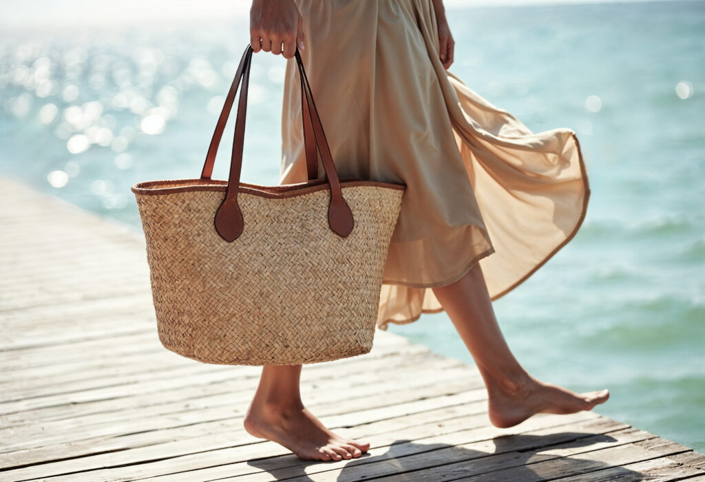 une-femme-marchant-sur-un-quai-en-bois-avec-un-sac-de-paille